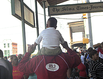 Derrick Stevens carries his grandson through Selma