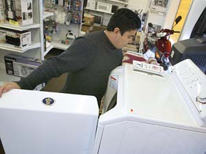 Juan Vazquez looks at a Maytag washer 