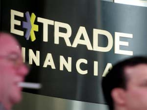 Pedestrians walk past an E*Trade Financial 