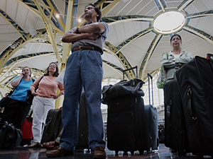 Travelers wait to check into their flights 