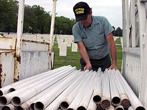 Steve Johnson, Ft. Snelling Cemetery worker picks out the poles that will hold Memorial Day flags.
