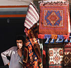 An Afghan rug merchant looks out of his shop ... 