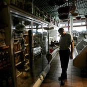 A grocery owener surveys a freezer full of ... 