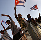 People wave Cuban flags from the back of a ... 
