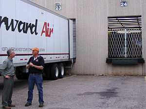 Freight forwarder Bob Masters of Manna Freight Systems speaks with the general manager of a facility owned by Forward Air, which transports some of Manna's freight. Since 9-11 both Manna and Forward Air have had to secure their buildings, by means including the metal gate pictured above.