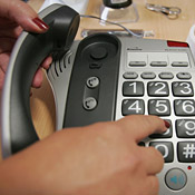 A woman dials a phone. 