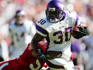 Mewelde Moore runs with the ball against T.J. Slaughter of the San Francisco 49ers.
