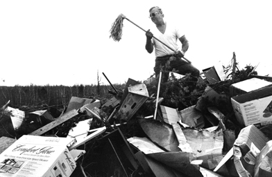 
                    Jerry Blackburn stands on a mound of trash at the Cherryfield Dump and Jerry victoriously excavates an old mop.
                                            (Alexandra Marvar)
                                        