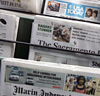 Newspapers are seen on display at a newspaper ... 