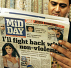 An Indian shopkeeper reads an afternoon ... 