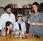 A family lights shabbat candles 