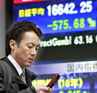 A businessman browses his mobile phone as he ... 