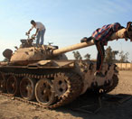 Iraqis play on a wrecked Iraqi army tank. 