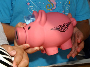 A child holds a piggy bank. 