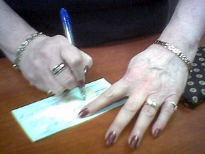A woman signs a check. 