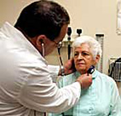 A doctor checks an elderly patient at a ... 