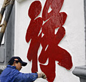 A worker repaints a Chinese caracter meaning ... 
