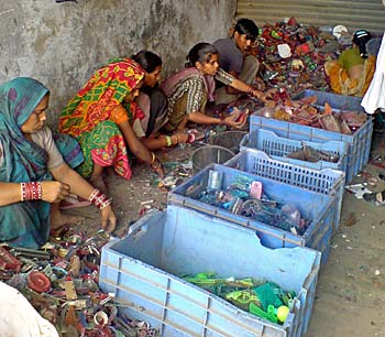 Workers sort scraps of plastic by color so it ... 