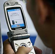 A man in Beijing sends a text message on his ... 