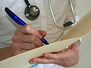 Doctor takes notes on a patient 