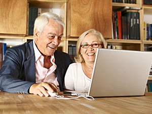 Senior couple in front of laptop 