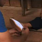 A member of the TOMs team puts a shoe on a ... 