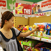 A woman inspects a Sesame Street toy 