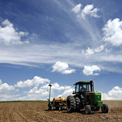 An Iowa farmer pulls a corn planter behind his ... 