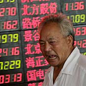 A Chinese investor reacts in front of a stock ... 