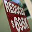 A sign announcing a reduced housing price