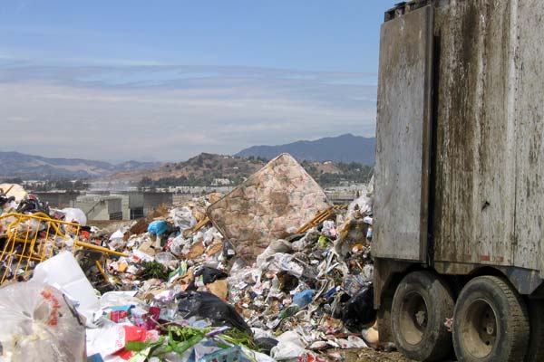 
                A large semi-truck empties its load of garbage onto a pile that is 209 acres and 170-feet deep.
                                    (Tess Vigeland)
                                