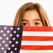 Girl hiding behind American flag 