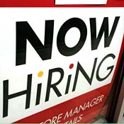 A "Now Hiring" sign displayed in a store window 