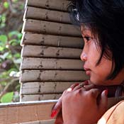 A slave girl peers out from behind shutters 
