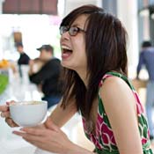 A woman laughs over a meal 