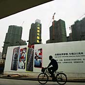 Man rides bike past construction in China 