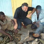 Father Christopher sits to talk with Haitian cane cutters in "The Price of Sugar."