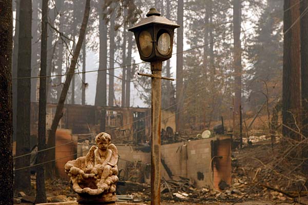 
                A statue and lamp post remain at the site of a  home destroyed by a wildfire in Running Springs, Calif. 
                                    (Justin Sullivan/Getty Images)
                                