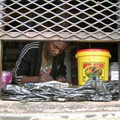 Vendor Talkmore Sitole in his concessions stand, Alexandra, Johannesburg. Sitole saves money by sleeping inside the stand, but says its a risk because of crime.