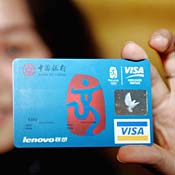 A woman displays a Visa credit card in Beijing 