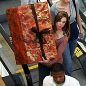 A woman carries a package off escalator 