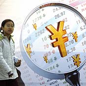 A Chinese girl walks past a financial billboard 