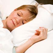 A woman rests her head on a pillow 