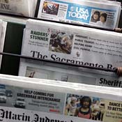 Newspapers displayed on a news stand 