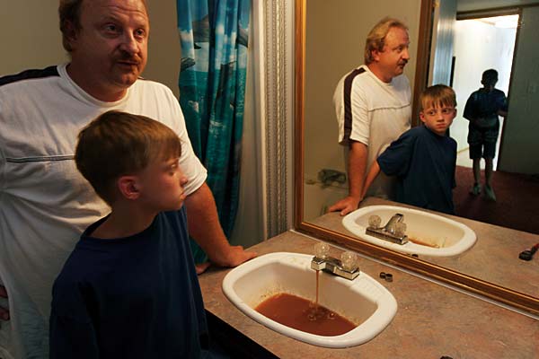 
                Foul-smelling water mixed with coal runs from Kenny Stroud's faucet in Rawl, W.Va. For years, residents of the Appalachian coal-mining town have had to rely on water trucks and deliveries for clean water.
                                    (Melissa Farlow/From Blue Planet Run)
                                