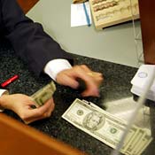 A bank teller dispenses cash 