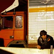 A trucker stands by his rig 