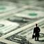 Man figure standing on dollar bills
