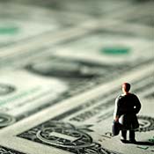 Man figure standing on dollar bills 