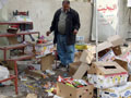 An Iraqi man inspects the damage to his shop.